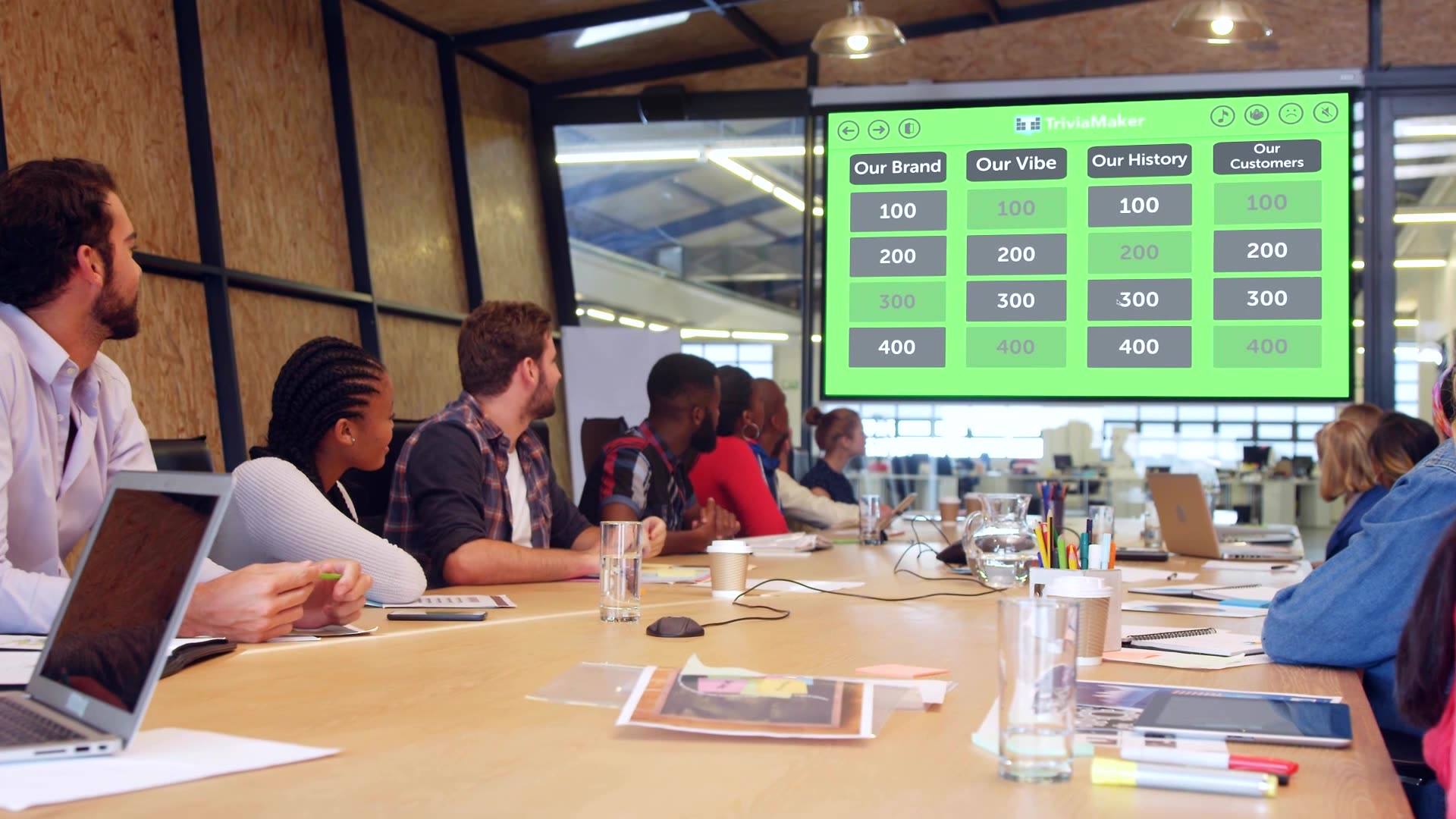 Corporate team playing TriviaMaker Grid-style quiz in boardroom  -  team building